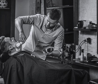 barber shaves a man