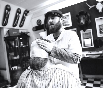 barber moisturizing a man's face